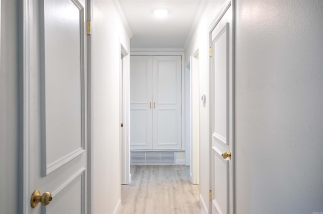 hall with ornamental molding and light hardwood / wood-style flooring