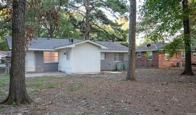 rear view of property with central AC