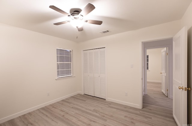 unfurnished bedroom featuring ceiling fan, a closet, and light hardwood / wood-style flooring