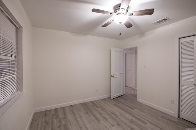 unfurnished bedroom featuring a closet, light wood-type flooring, and ceiling fan