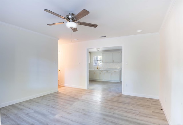 unfurnished room with ceiling fan, light wood-type flooring, crown molding, and sink