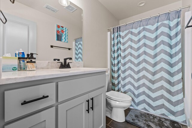 bathroom featuring tile patterned floors, toilet, vanity, and curtained shower