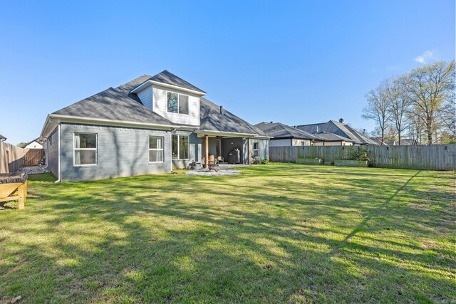 rear view of house with a yard and a patio area