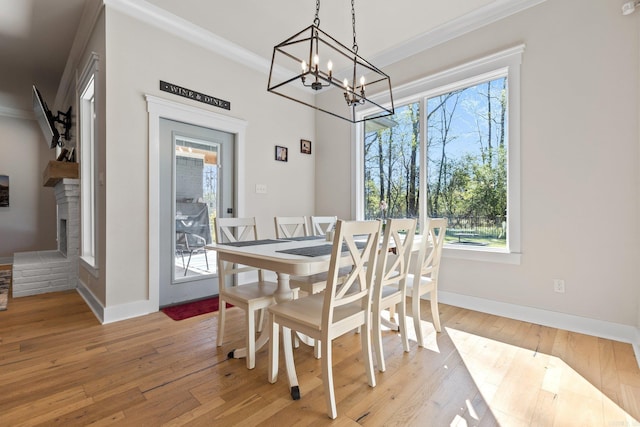 dining space with light hardwood / wood-style flooring, crown molding, and a healthy amount of sunlight