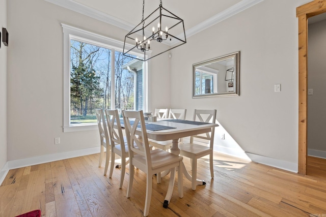 dining room featuring light hardwood / wood-style flooring, a chandelier, and ornamental molding