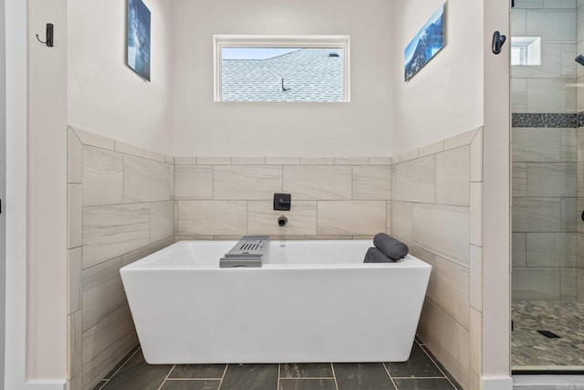 bathroom featuring tile walls and independent shower and bath