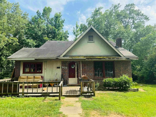 view of front of house featuring a deck and a front lawn