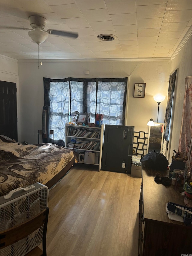 bedroom featuring crown molding, ceiling fan, and wood-type flooring