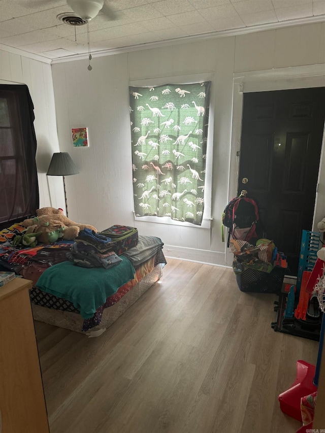 bedroom featuring ornamental molding, ceiling fan, and wood-type flooring