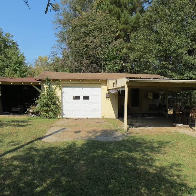 garage featuring a carport and a yard