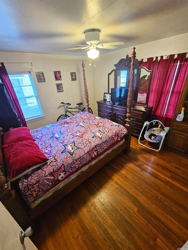 bedroom featuring a textured ceiling, multiple windows, dark hardwood / wood-style floors, and ceiling fan