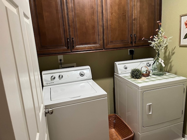 washroom with washing machine and dryer and cabinets