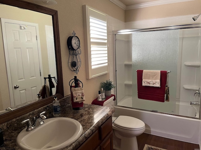 full bathroom featuring combined bath / shower with glass door, toilet, wood-type flooring, ornamental molding, and vanity