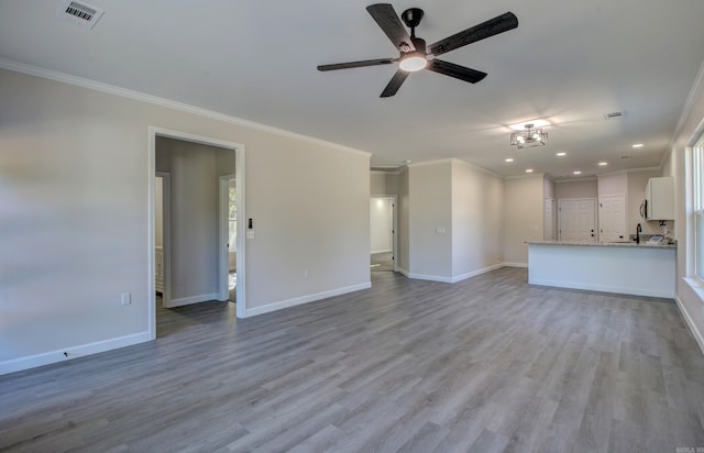 unfurnished living room featuring light hardwood / wood-style floors, ornamental molding, and ceiling fan