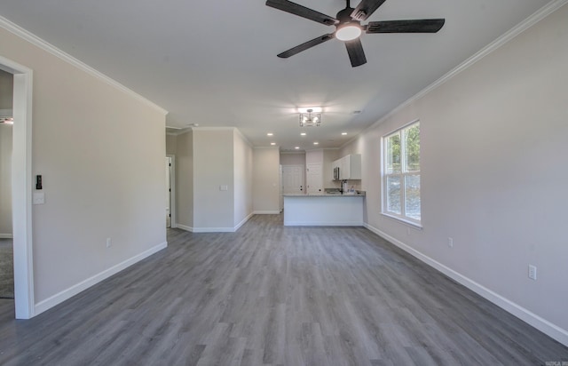 unfurnished living room with crown molding, ceiling fan, and wood-type flooring