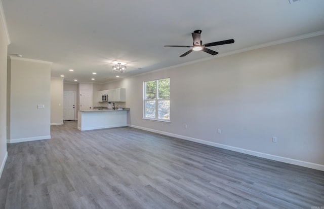 unfurnished living room with crown molding and light hardwood / wood-style floors