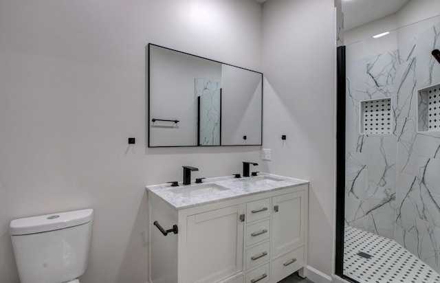 bathroom with a tile shower, toilet, and vanity