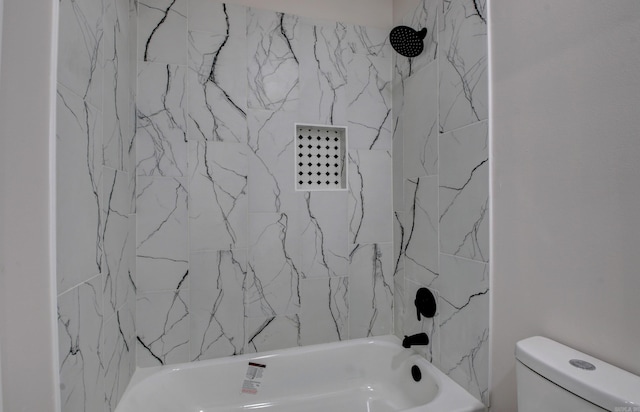 bathroom with tiled shower / bath combo and toilet