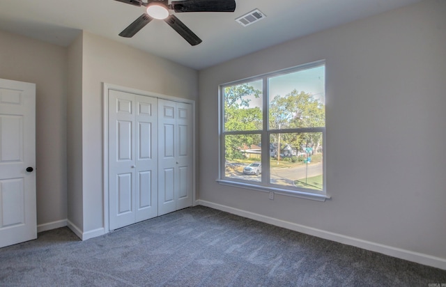 unfurnished bedroom with ceiling fan, a closet, and carpet