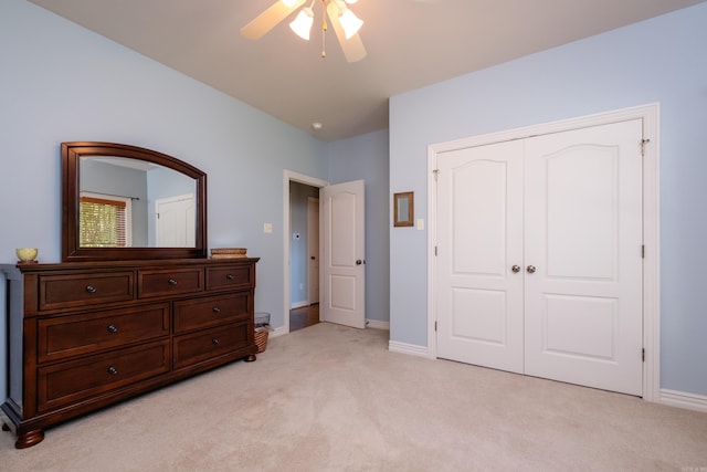 carpeted bedroom with ceiling fan and a closet