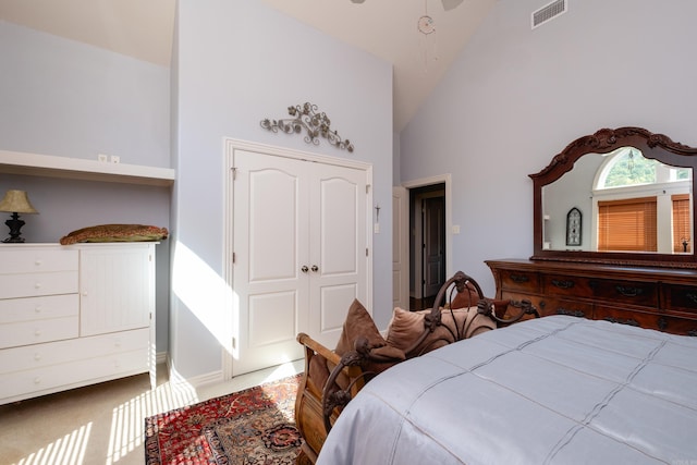 carpeted bedroom featuring high vaulted ceiling and a closet