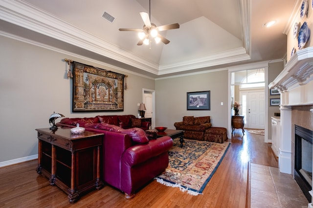 living room featuring a fireplace, ornamental molding, hardwood / wood-style flooring, and ceiling fan