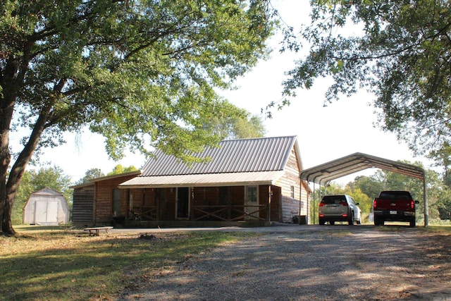 view of front of property with a carport and a storage shed