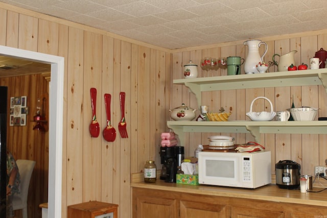 bar with wood walls and light brown cabinets