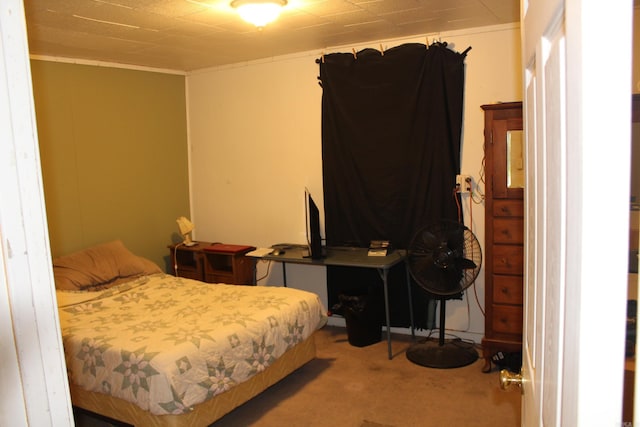 bedroom with ornamental molding and carpet flooring