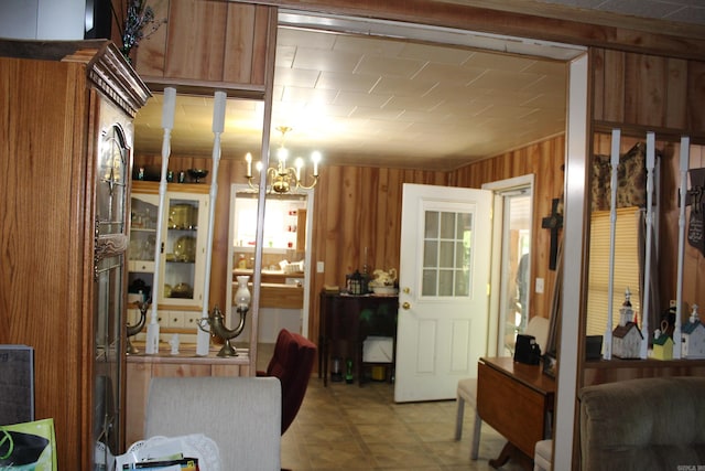 interior space with an inviting chandelier and wooden walls