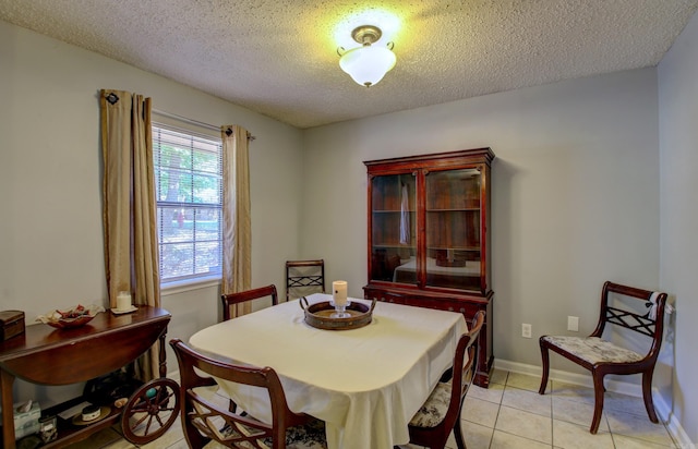 tiled dining room featuring a textured ceiling