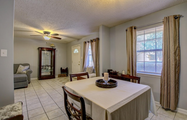 dining area featuring ceiling fan, plenty of natural light, light tile patterned floors, and a textured ceiling