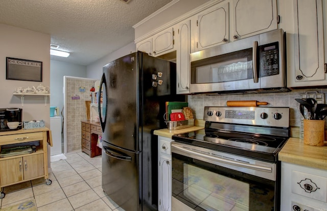 kitchen with decorative backsplash, appliances with stainless steel finishes, light tile patterned floors, and a textured ceiling