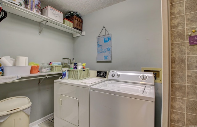 clothes washing area featuring a textured ceiling and washer and dryer