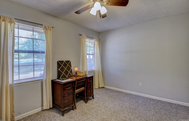 office area with ceiling fan, a textured ceiling, and light carpet