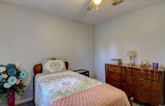 carpeted bedroom featuring ceiling fan and a textured ceiling