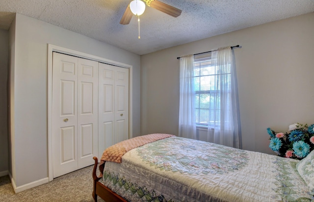 bedroom with ceiling fan, a closet, carpet, and a textured ceiling