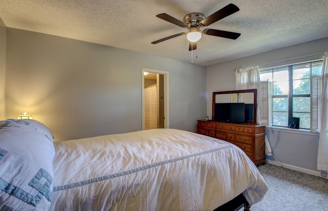 carpeted bedroom with ceiling fan and a textured ceiling