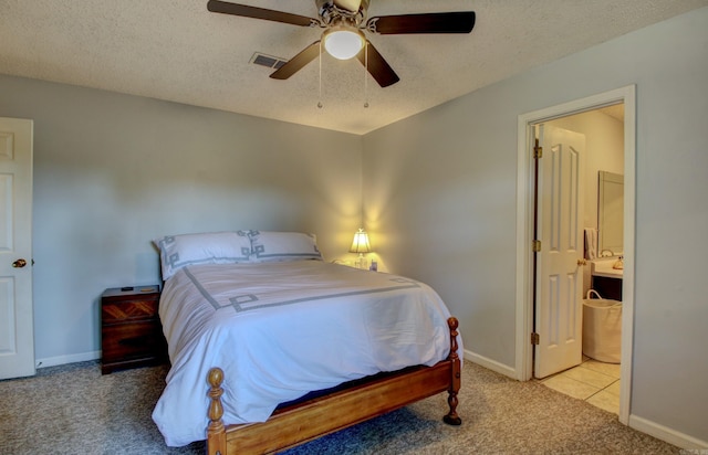 carpeted bedroom featuring ceiling fan, a textured ceiling, and ensuite bathroom