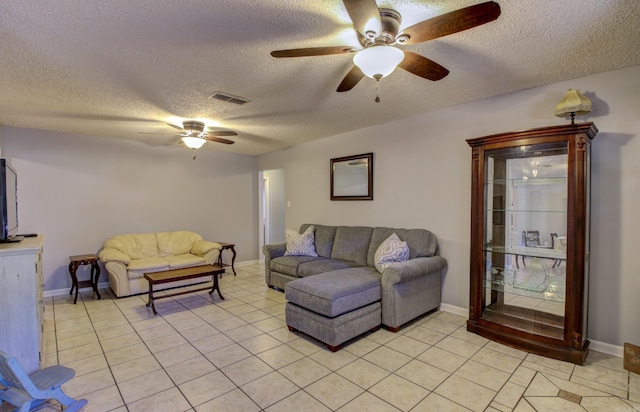 living room with ceiling fan, a textured ceiling, and light tile patterned floors