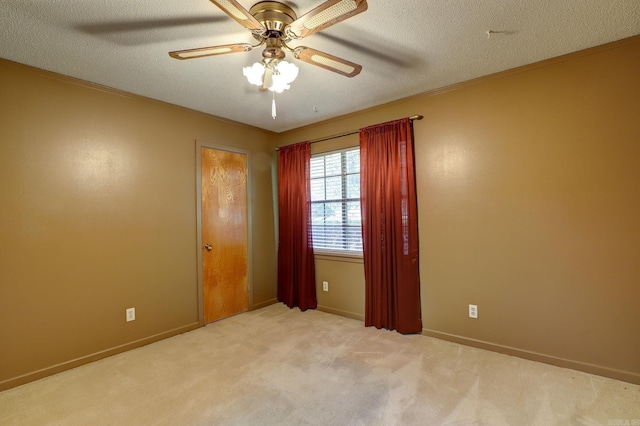 empty room featuring ceiling fan, a textured ceiling, and light carpet