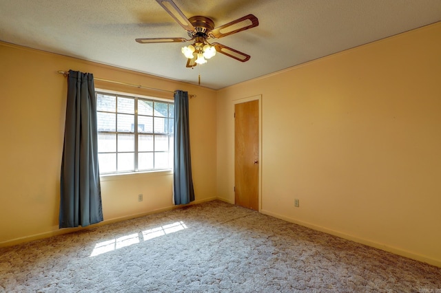 carpeted spare room featuring ceiling fan and a textured ceiling