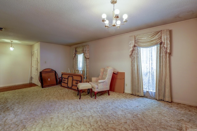 living area with an inviting chandelier, a textured ceiling, carpet, and a healthy amount of sunlight