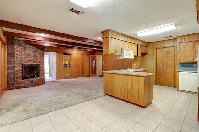 kitchen with beamed ceiling, kitchen peninsula, white appliances, a textured ceiling, and light colored carpet