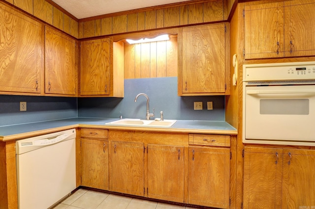 kitchen with white appliances, sink, light tile patterned floors, and a textured ceiling