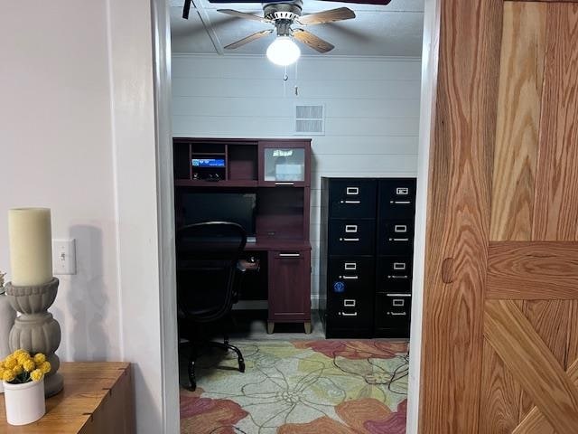 home office with ceiling fan and wooden walls