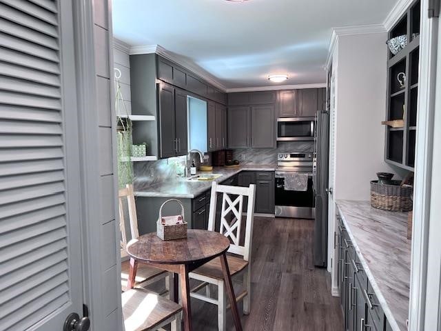 kitchen featuring gray cabinetry, dark wood-type flooring, sink, appliances with stainless steel finishes, and backsplash