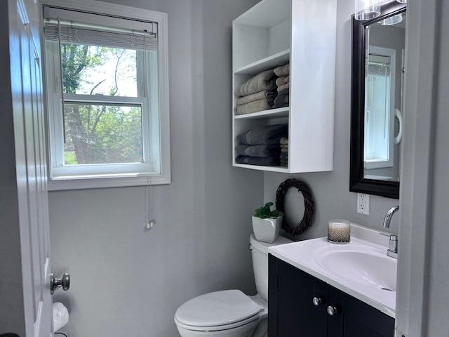 bathroom featuring vanity, plenty of natural light, and toilet