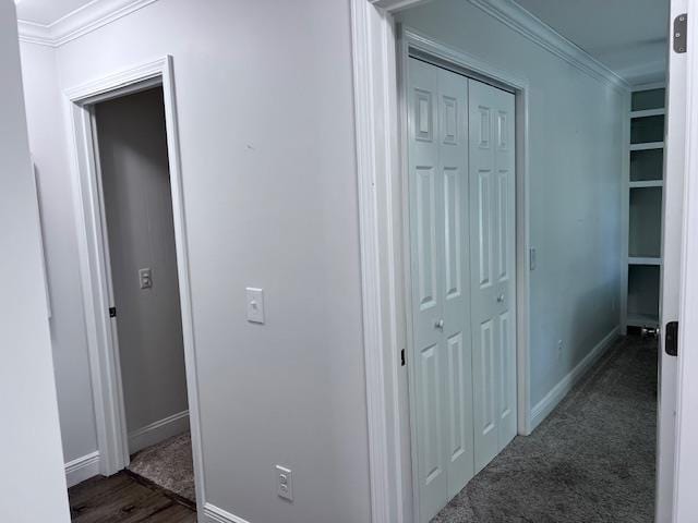 hallway featuring crown molding and dark carpet