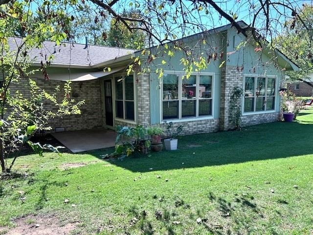 back of house with a yard and a patio